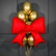 Композиция из золотых шаров с красным бантом