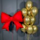 Композиция из золотых шаров с красным бантом